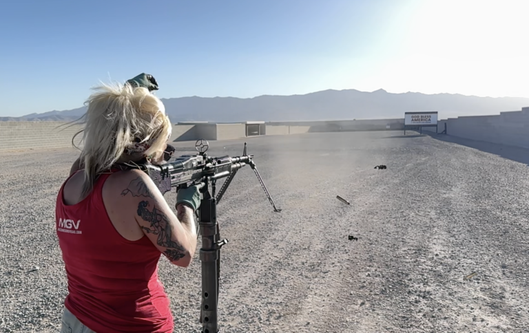 A shooter in a Machine Guns Vegas shirt fires a belt-fed machine gun at the outdoor desert range